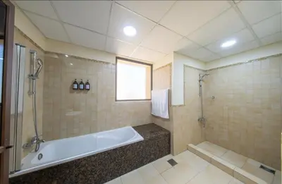 a bathroom with a bath tub and a shower at Lux 4BR JBR I Sea View I Walk to Beach I Sleeps 12 in Dubai