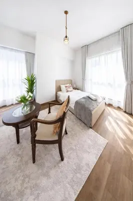 a bedroom with a bed and a table and a chair at Lux 4BR JBR I Sea View I Walk to Beach I Sleeps 12 in Dubai