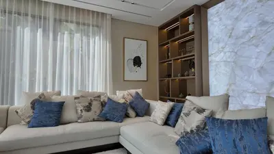 a living room with a white couch with blue pillows at World Class 6 BDR Villa In Signature Palm in Dubai