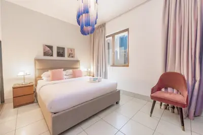 a bedroom with a bed and a red chair at Fam Living Reehan Old Town 2BR Plus Maids Apt in Dubai