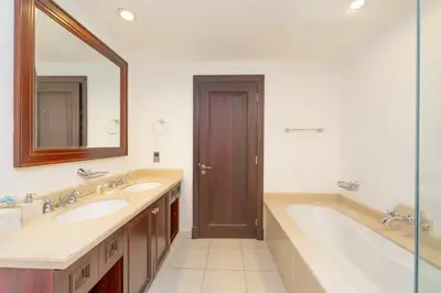 a bathroom with two sinks and a tub and a mirror at Fam Living Reehan Old Town 2BR Plus Maids Apt in Dubai