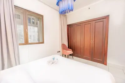 a bedroom with a bed and a chair and a window at Fam Living Reehan Old Town 2BR Plus Maids Apt in Dubai