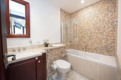 a bathroom with a toilet and a tub and a sink at Fam Living Reehan Old Town 2BR Plus Maids Apt in Dubai