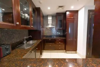 a kitchen with wooden cabinets and a sink at Fam Living Reehan Old Town 2BR Plus Maids Apt in Dubai