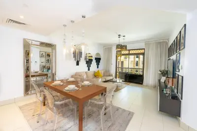 a living room with a wooden table and chairs at Fam Living Reehan Old Town 2BR Plus Maids Apt in Dubai