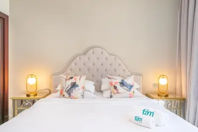 a bedroom with a white bed with two lamps at Fam Living Reehan Old Town 2BR Plus Maids Apt in Dubai