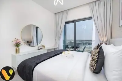 a bedroom with a large white bed and a large window at Vogue Al Maktoum City Sobha Hartland Waves Near to Downtown, Burj Khalifa and Dubai Mall, One Bedroom Apartment plus Kids room with Balcony and City View, Access to all Amenities in Dubai