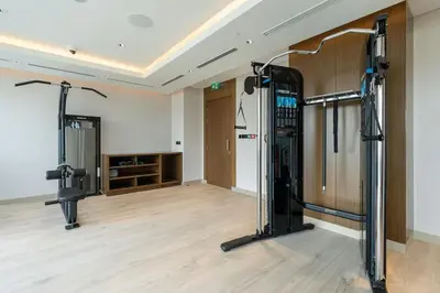 a room with a gym with a treadmill at Vogue Al Maktoum City Sobha Hartland Waves Near to Downtown, Burj Khalifa and Dubai Mall, One Bedroom Apartment plus Kids room with Balcony and City View, Access to all Amenities in Dubai