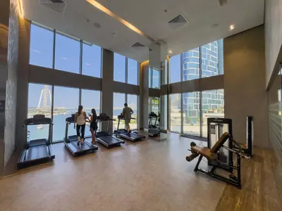 a gym with people exercising on treadmills in a building at StayShort - Luxury 1 Bedroom Apartment in Dubai Marina Sleeps 4 in Dubai