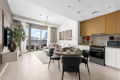 a kitchen and living room with a table and chairs at StayShort - Luxury 1 Bedroom Apartment in Dubai Marina Sleeps 4 in Dubai