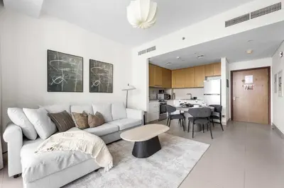 a living room with a couch and a table and a kitchen at StayShort - Luxury 1 Bedroom Apartment in Dubai Marina Sleeps 4 in Dubai