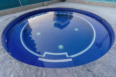 a blue swimming pool with stairs in the water at Chic Studio Canal Side Speedy wi-fi BBay in Dubai