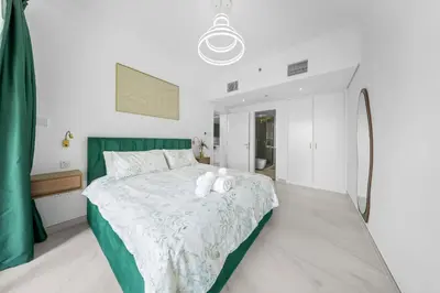 a bedroom with a bed with a teddy bear on it at Emerald Luxury Suite DMCC Metro station in Dubai