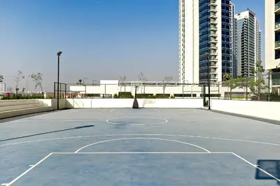 a basketball court in a city with a building at Stylish 1BR Apartment at Damac Hills Golf Gate in Dubai