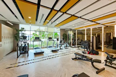 a gym with a lot of treadmills and machines at Stylish 1BR Apartment at Damac Hills Golf Gate in Dubai