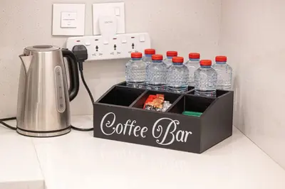 a coffee bar with bottles of water on a counter at Mahogany 21 - 4BR - Dubai Mall Walk & Burj Khalifa in Dubai