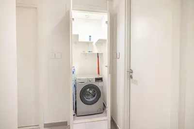 a washer and dryer in a white laundry room at Mahogany 21 - 4BR - Dubai Mall Walk & Burj Khalifa in Dubai