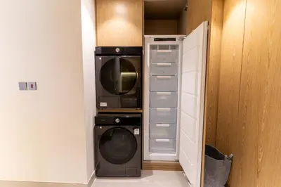 a closet with a microwave and a washer and dryer at 3BR apartment in the one of the tallest tower in Marina in Dubai