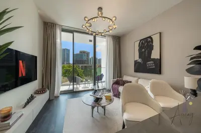a living room with a couch and a chandelier at Luxury Modern 1BR Paragon by Igo Downtown 1BR in Dubai