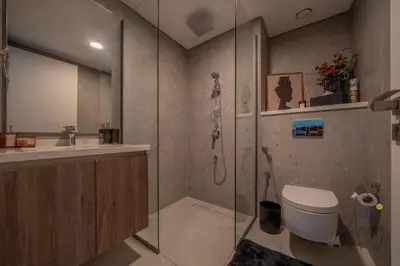 a bathroom with a shower and a toilet and a sink at Luxury Modern 1BR Paragon by Igo Downtown 1BR in Dubai