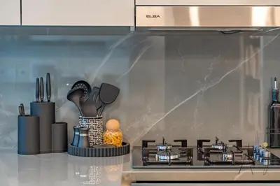 a kitchen counter with a stove and some utensils at Luxury 1BR Paragon by IGO BURJ khalifa View in Dubai