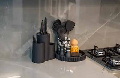 a bunch of utensils sitting on a counter next to a stove at Luxury 1BR Paragon by IGO BURJ khalifa View in Dubai