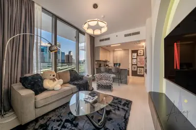 a living room with a teddy bear sitting on a couch at Luxury 1BR Paragon by IGO BURJ khalifa View in Dubai