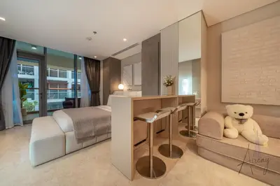 a bedroom with a bed and a desk with a teddy bear at Sleek & Glam Downtown Studio Near Burj Khalifa in Dubai