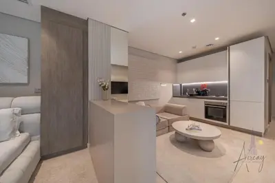 a kitchen and living room with a couch and a table at Sleek & Glam Downtown Studio Near Burj Khalifa in Dubai