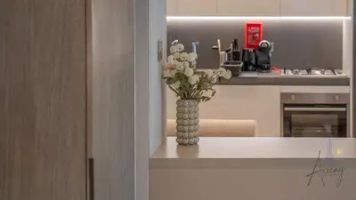 a vase of flowers sitting on a counter in a kitchen at Sleek & Glam Downtown Studio Near Burj Khalifa in Dubai