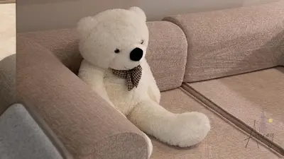 a white teddy bear sitting on a couch at Sleek & Glam Downtown Studio Near Burj Khalifa in Dubai