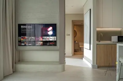 a living room with a television on a wall at Luxe Missoni-Inspired 1BR Sky-High Living in Dubai