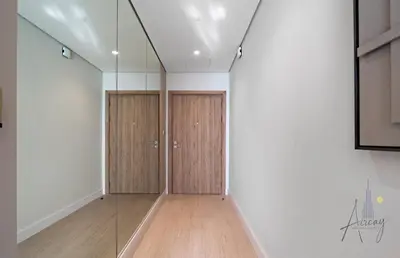 a corridor with wooden doors in a white room at Luxe Missoni-Inspired 1BR Sky-High Living in Dubai