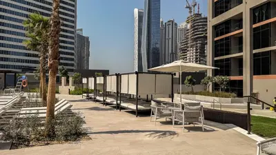 a patio with chairs and an umbrella in a city at Luxe Missoni-Inspired 1BR Sky-High Living in Dubai