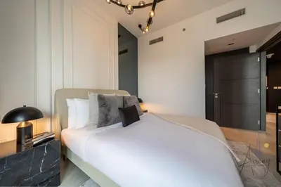 a bedroom with a white bed and a black door at Upscale 1BR Paragon by IGO Near Downtown in Dubai