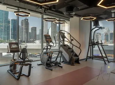 a gym with cardio equipment and a view of the city at Upscale 1BR Paragon by IGO Near Downtown in Dubai