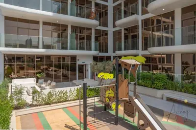 a playground in front of a tall building at Urban Oasis 1BR Designer Nest Chic & Cosy in Dubai
