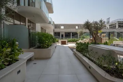 a courtyard of a building with benches and plants at Boutique 1BR Escape Cosy & Classy JVC in Dubai