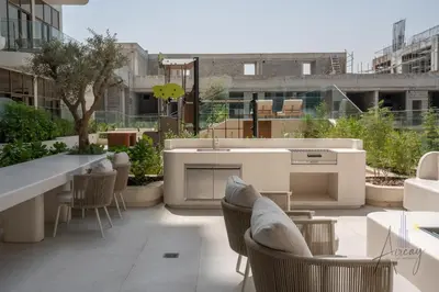 a rooftop patio with a kitchen and tables and chairs at Boutique 1BR Escape Cosy & Classy JVC in Dubai
