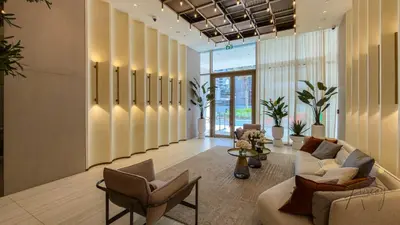 a lobby with couches and chairs in a building at Boutique 1BR Escape Cosy & Classy JVC in Dubai