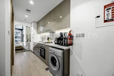 a kitchen with a washer and dryer in it at Bloomfields Modern STU Azizi Riviera in Dubai