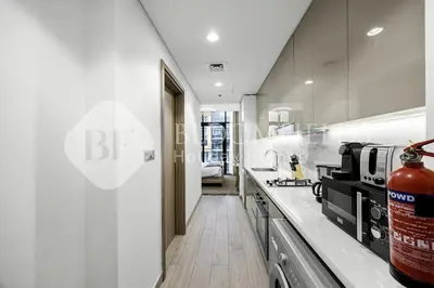 a kitchen with white walls and a counter top at Bloomfields Modern STU Azizi Riviera in Dubai