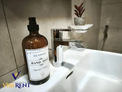 a bottle of hand soap sitting on a bathroom sink at Supreme joy in Arjan 1 BHK in Dubai
