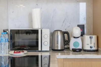 a kitchen counter with a microwave and a coffee maker at Luxe Royal Amwaj Palm Jumeirah Beach Access in Dubai
