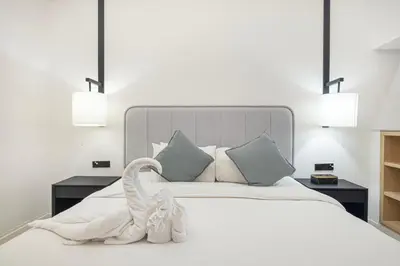 a white bed with a swan towel on it at Luxe Royal Amwaj Palm Jumeirah Beach Access in Dubai
