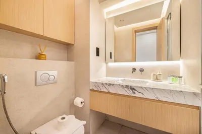 a bathroom with a sink and a toilet and a mirror at Luxe Royal Amwaj Palm Jumeirah Beach Access in Dubai