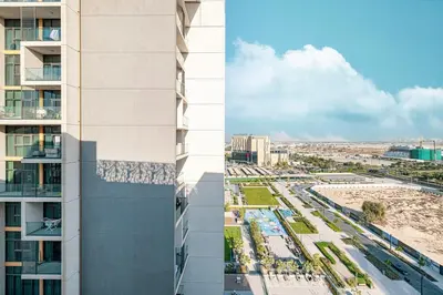 two images of a building and a city at Swanky Studio with Balcony in Dubai Hills Estate in Dubai