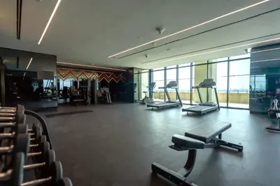 a gym with treadmills and exercise equipment in a building at Balcony Facing a Partial Canal View, Close to Metro and Marine Transport, Downtown Attractions Just a Ride Away, Urban Oasis, Business Bay by Deluxe Holiday Homes in Dubai