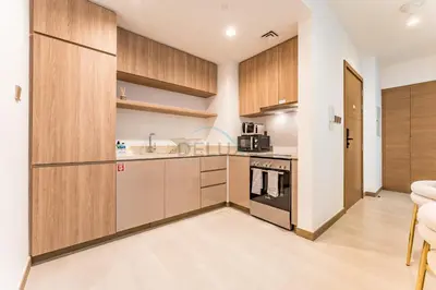a kitchen with wooden cabinets and a sink at Balcony Facing a Partial Canal View, Close to Metro and Marine Transport, Downtown Attractions Just a Ride Away, Urban Oasis, Business Bay by Deluxe Holiday Homes in Dubai
