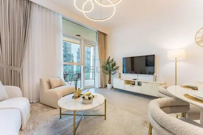a living room with white furniture and a flat screen tv at Balcony Facing a Partial Canal View, Close to Metro and Marine Transport, Downtown Attractions Just a Ride Away, Urban Oasis, Business Bay by Deluxe Holiday Homes in Dubai